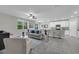 Bright open-concept living room with tile floors flowing into the modern kitchen with white cabinetry at 17309 Cagan Crossing Blvd, Clermont, FL 34714