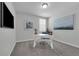 Bright home office featuring carpet, a modern desk, and a large window with a view at 17309 Cagan Crossing Blvd, Clermont, FL 34714