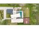 Aerial shot of a modern home featuring a pool, basketball court, solar panels, and green landscaping at 1766 Alaqua Dr, Longwood, FL 32779