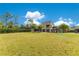 Expansive backyard featuring a modern stone home, palm trees, and lush green lawn at 1766 Alaqua Dr, Longwood, FL 32779