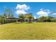 Large grassy backyard showcasing a contemporary stone home with palm trees and greenery at 1766 Alaqua Dr, Longwood, FL 32779