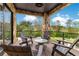 Covered balcony with stone pillars, seating, and views of the landscaped yard at 1766 Alaqua Dr, Longwood, FL 32779