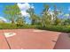 Red basketball court surrounded by tall hedges on residential property at 1766 Alaqua Dr, Longwood, FL 32779