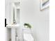 Clean, minimalist powder room with pedestal sink, toilet, and decorative plant at 1766 Alaqua Dr, Longwood, FL 32779