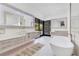 Luxurious bathroom with dual vanities, soaking tub, and modern mirrors, seamlessly blending elegance and comfort at 1766 Alaqua Dr, Longwood, FL 32779