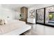 Spacious bedroom featuring a stone accent wall, sleek platform bed, and access to an outdoor patio at 1766 Alaqua Dr, Longwood, FL 32779