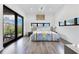 Bright bedroom with wood floors, modern lighting, large windows, and access to outdoor balcony at 1766 Alaqua Dr, Longwood, FL 32779