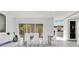 Modern dining room with a glass table, white chairs, and view into the outdoor area at 1766 Alaqua Dr, Longwood, FL 32779