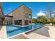 A modern home boasts a large swimming pool, multiple outdoor living spaces, and a striking stone exterior at 1766 Alaqua Dr, Longwood, FL 32779