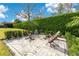 Relaxing backyard fire pit with wood chairs and manicured hedges at 1766 Alaqua Dr, Longwood, FL 32779