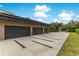 Three car garage with a decorative driveway and manicured lawn at 1766 Alaqua Dr, Longwood, FL 32779