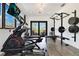 Home gym featuring an elliptical, weight rack, TV and access to outdoor patio at 1766 Alaqua Dr, Longwood, FL 32779