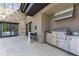 Stainless steel outdoor kitchen with tile patio and bar stool seating at 1766 Alaqua Dr, Longwood, FL 32779