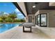 An expansive patio with a pool table connects to the interior with views of a sparkling pool and lush landscaping at 1766 Alaqua Dr, Longwood, FL 32779