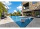 A luxurious backyard oasis featuring a stone facade, a built-in bar, and a sparkling pool with a sun lounger at 1766 Alaqua Dr, Longwood, FL 32779