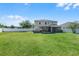 Wide shot of an expansive backyard with lush green grass and a two-story house at 199 Boysenberry Ln, Daytona Beach, FL 32124