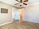 Bright bedroom featuring laminate floors, ceiling fan, closet with mirrored doors, and an open doorway to another room at 200 Saint Andrews Blvd # 1004, Winter Park, FL 32792