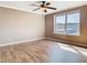 Bedroom with hardwood flooring, ceiling fan, and large window at 200 Saint Andrews Blvd # 1004, Winter Park, FL 32792