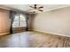 A serene bedroom features wood-look floors, a window with elegant curtains, and neutral walls, creating a calming atmosphere at 200 Saint Andrews Blvd # 1004, Winter Park, FL 32792