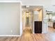 View of the hallway leading into the kitchen with wood-look floors and neutral paint at 200 Saint Andrews Blvd # 1004, Winter Park, FL 32792