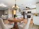 Open-concept kitchen with stainless steel appliances, white cabinets, and a cozy dining area at 200 Saint Andrews Blvd # 1004, Winter Park, FL 32792
