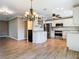 Open kitchen and dining area with updated stainless steel appliances, granite countertops, and white cabinetry at 200 Saint Andrews Blvd # 1004, Winter Park, FL 32792