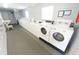 Well-lit laundry room featuring rows of modern, energy-efficient washing machines for resident convenience at 200 Saint Andrews Blvd # 1004, Winter Park, FL 32792