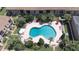 Aerial view of a kidney-shaped community pool surrounded by lush landscaping and lounge chairs at 200 Saint Andrews Blvd # 1004, Winter Park, FL 32792