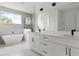 Modern bathroom features a soaking tub, tiled accent wall, and double sink vanity at 2408 Lafayette Ave, Winter Park, FL 32789