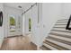 Bright and inviting foyer with hardwood floors, staircase, and modern sliding door at 2408 Lafayette Ave, Winter Park, FL 32789