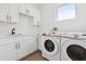 Modern laundry room with white cabinets, stainless steel sink, and full size appliances at 2408 Lafayette Ave, Winter Park, FL 32789