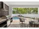Outdoor kitchen and entertaining space with a grill, seating area, and a view of the pool at 2408 Lafayette Ave, Winter Park, FL 32789