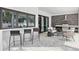 Covered patio with a bar counter, outdoor kitchen, lounge seating, and elegant tiled flooring at 2408 Lafayette Ave, Winter Park, FL 32789