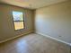 This cozy bedroom features neutral walls and flooring and a window with a view at 2431 Lackland Dr, Deltona, FL 32738