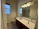 Bathroom featuring a vanity with a large mirror, bathtub, tiled walls and natural light from a window at 2715 Bartlet Dr, Kissimmee, FL 34741
