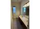 Bright bathroom featuring tile floors, modern lighting, and vanity with a solid surface countertop at 2715 Bartlet Dr, Kissimmee, FL 34741