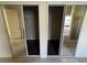 Bedroom closet with mirrored sliding doors; one closet is open to reveal hanging storage at 2715 Bartlet Dr, Kissimmee, FL 34741