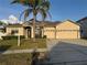 Charming single-story home with a three car garage, well-manicured lawn, and a mature palm tree in the front yard at 2715 Bartlet Dr, Kissimmee, FL 34741