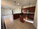 Spacious kitchen with wooden cabinets, stainless steel appliances and a kitchen island, with a view to the Gathering room at 2715 Bartlet Dr, Kissimmee, FL 34741