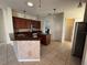Kitchen with dark wood cabinets, stainless steel appliances, and adjacent pantry and laundry room at 2715 Bartlet Dr, Kissimmee, FL 34741