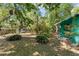 View of the secluded backyard featuring mature trees, lush greenery, and ample space for outdoor activities at 290 Pine St, Ormond Beach, FL 32174