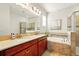 Bathroom featuring a double vanity, a soaking tub, and a glass-enclosed shower at 3053 Brook Stone Ter, Davenport, FL 33837