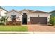 Charming single-Gathering home featuring a tile roof, brick driveway, and well-manicured landscaping at 3053 Brook Stone Ter, Davenport, FL 33837