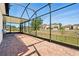 Large screened-in patio with brick pavers overlooking the manicured backyard and neighborhood beyond at 3053 Brook Stone Ter, Davenport, FL 33837