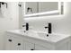 Bathroom showcasing a modern double sink vanity with an illuminated mirror and black hardware at 4087 Clock Tower Dr, Port Orange, FL 32129
