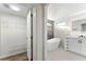 Bathroom featuring a modern vanity with an illuminated mirror, a soaking tub, and an adjacent closet at 4087 Clock Tower Dr, Port Orange, FL 32129