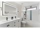 Modern bathroom with a double sink vanity, illuminated mirror, and a tub with shower at 4087 Clock Tower Dr, Port Orange, FL 32129