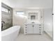 Bright bathroom featuring a modern vanity, a sleek soaking tub, and a stylish, illuminated mirror at 4087 Clock Tower Dr, Port Orange, FL 32129