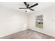 Cozy bedroom with wood-look flooring, a ceiling fan, and a window with neighborhood views at 4087 Clock Tower Dr, Port Orange, FL 32129