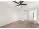 Well-lit bedroom featuring wood-look floors, a ceiling fan, closet, and an open doorway at 4087 Clock Tower Dr, Port Orange, FL 32129